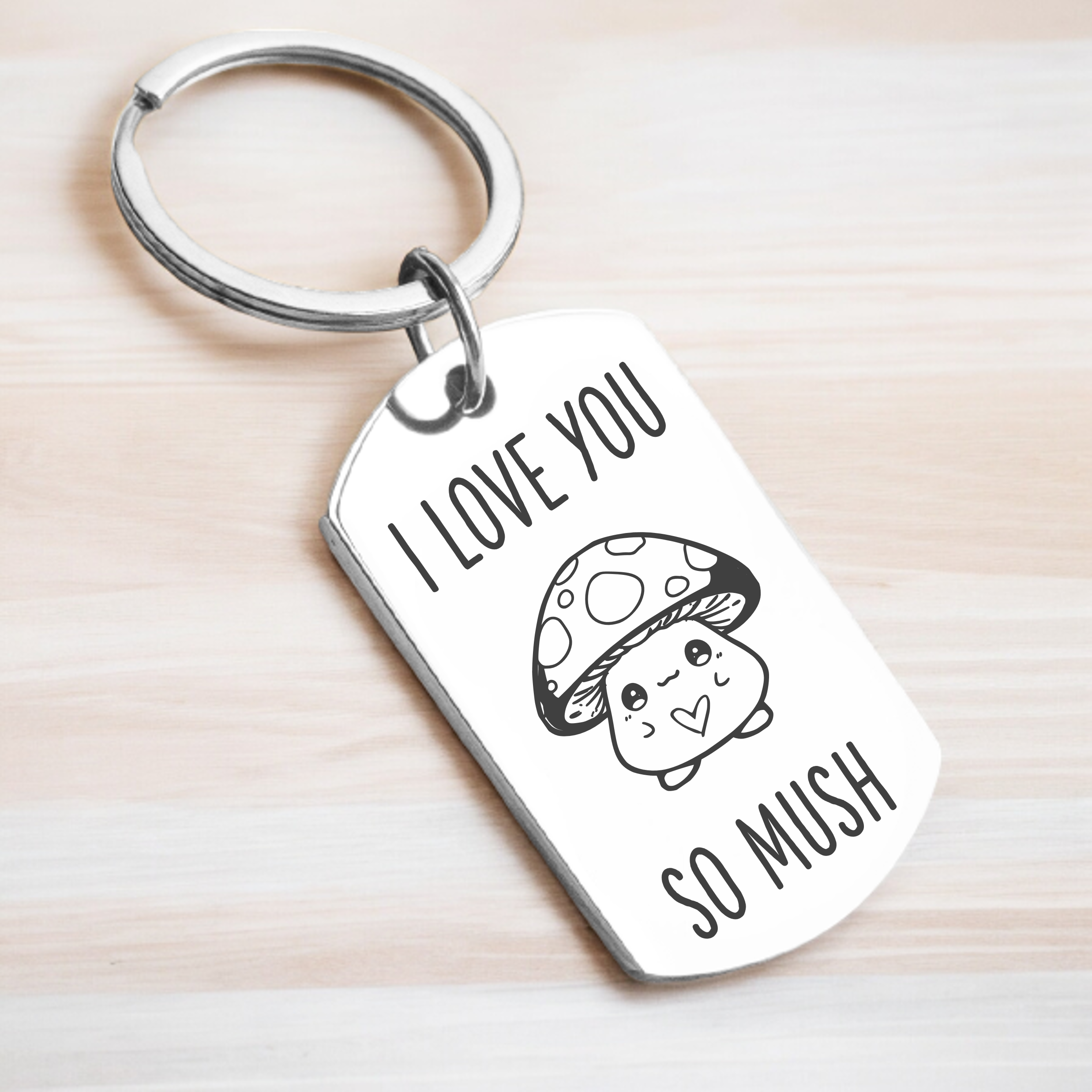 A key ring with a rectangular key chain attachment featuring an engraved message 'I love you so much' with a cute mushroom illustration.