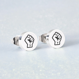 Pair of earring studs with Resist Fist Logo on blue background