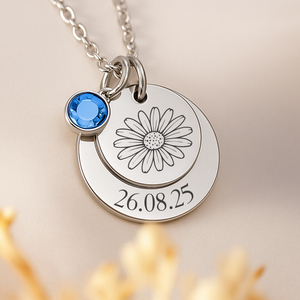 Silver necklace with a flower charm and birthstone on a beige background