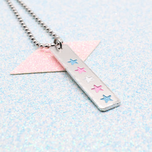 LGBTQ+ Transgender Necklace bar pendant featuring colourful star designs representing the transgender pride flag on a light blue background on a Ball Chain