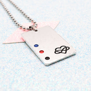 Polyamory Necklace with a rectangular tag featuring a polyamorous symbol and accents on a ball chain displayed on a light blue background