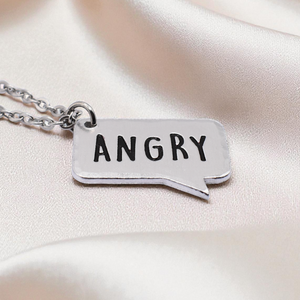 Silver necklace with a pendant labeled 'ANGRY' on a soft pink background