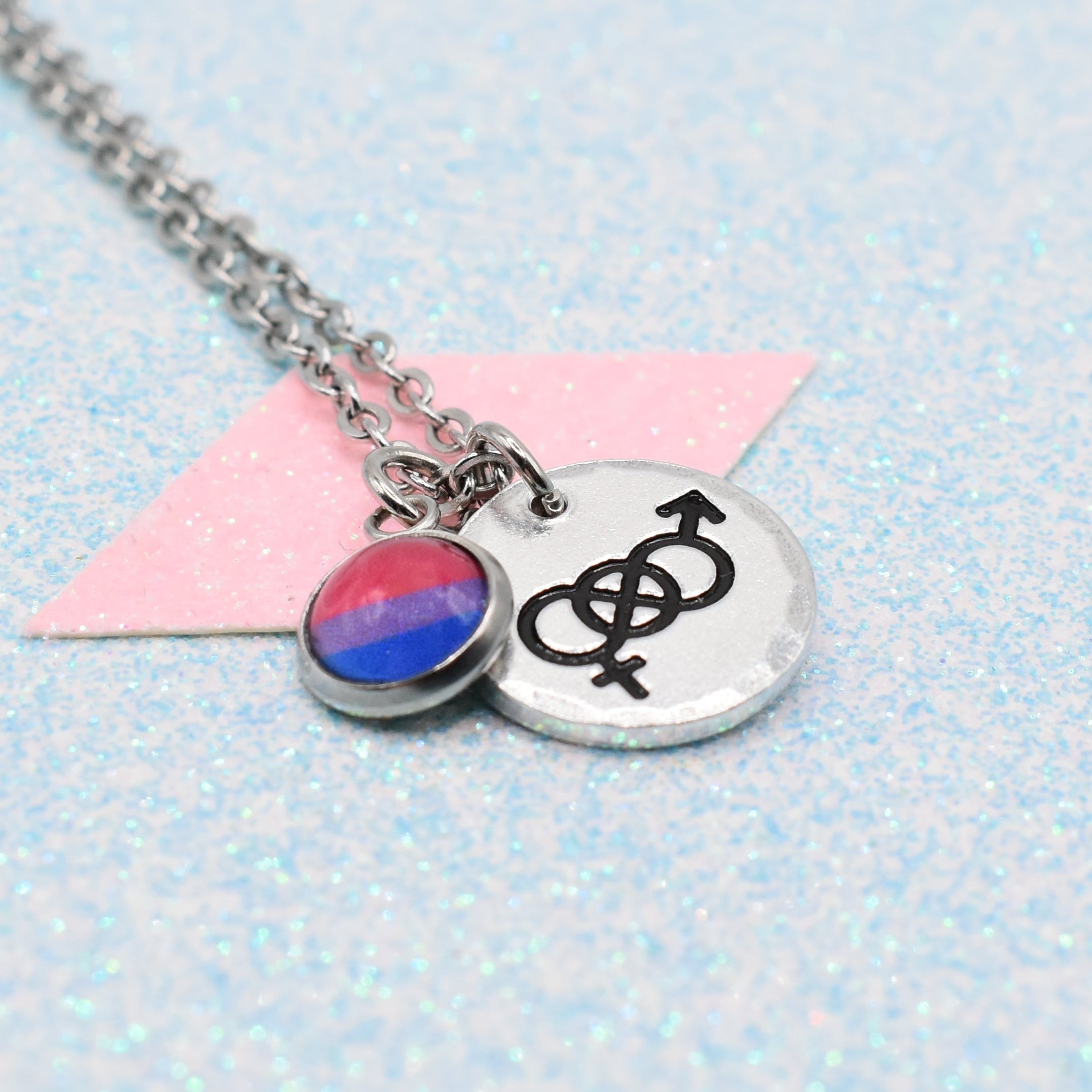 Necklace with bisexual pride symbol and gender equality symbol on a light blue background