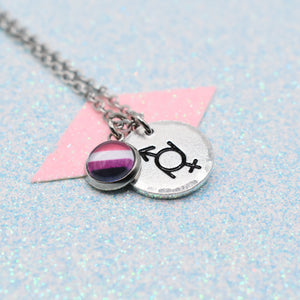Gender Fluid Pride Symbol Necklace with Pride Flag charm on a glittery surface
