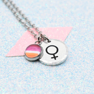 Lesbian Pride Necklace with a Pride Flag charm and a female symbol charm on a light blue background.
