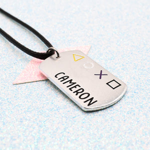 Silver dog tag non binary pride pendant with 'Cameron' engraved on a light blue background