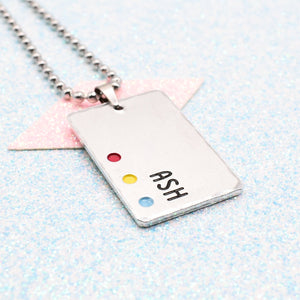 Customisable LGBTQ+ Pride Necklace featuring enamels of the pansexual pride flag and a personalised name mounted on a ball chain displayed on a blue background