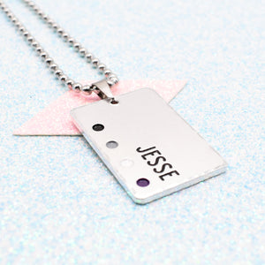 Customisable LGBTQ+ Pride Necklace featuring enamels of the Asexual pride flag and a personalised name mounted on a ball chain displayed on a blue background