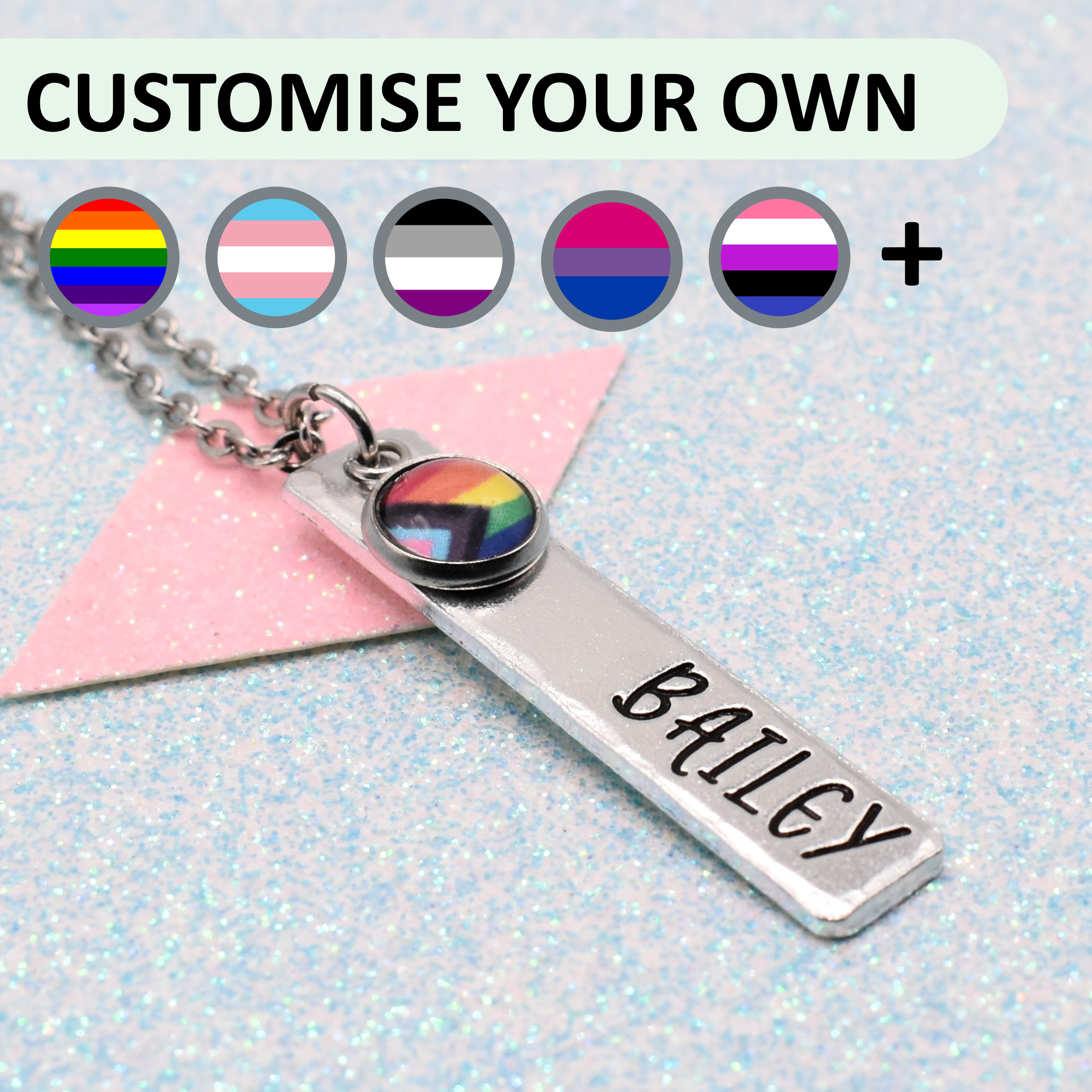 Personalised pride necklace with customisable LGBTQ+ pride flag and name 'personalisation' on a light blue glittery background.