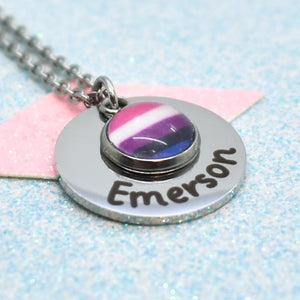 A gender fluid necklace with a round pendant featuring a colourful gender fluid pride flag design, with a personalised name written on the front.