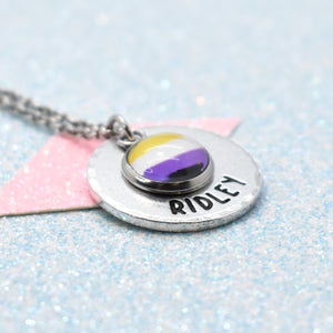 Pride Necklace with a round pendant featuring a non binary flag design and a hand-stamped name on a glittery background.