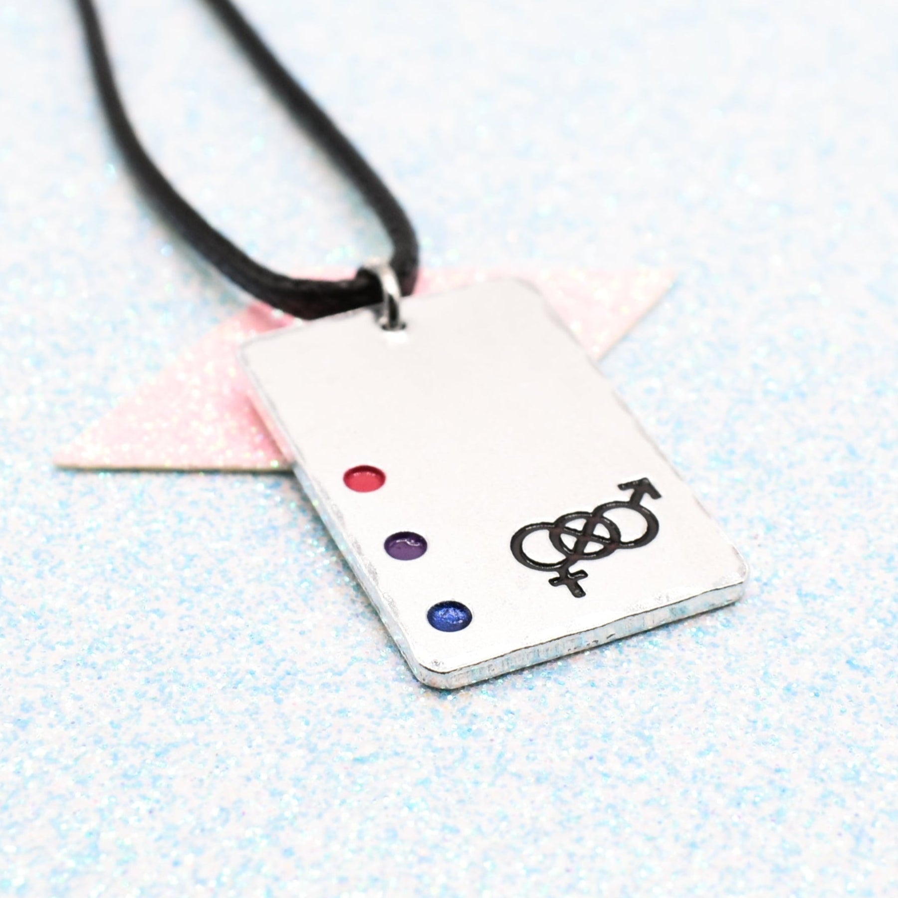 Bisexual Necklace with a rectangular tag featuring a Bisexual symbol and accents on a leather cord displayed on a light blue background