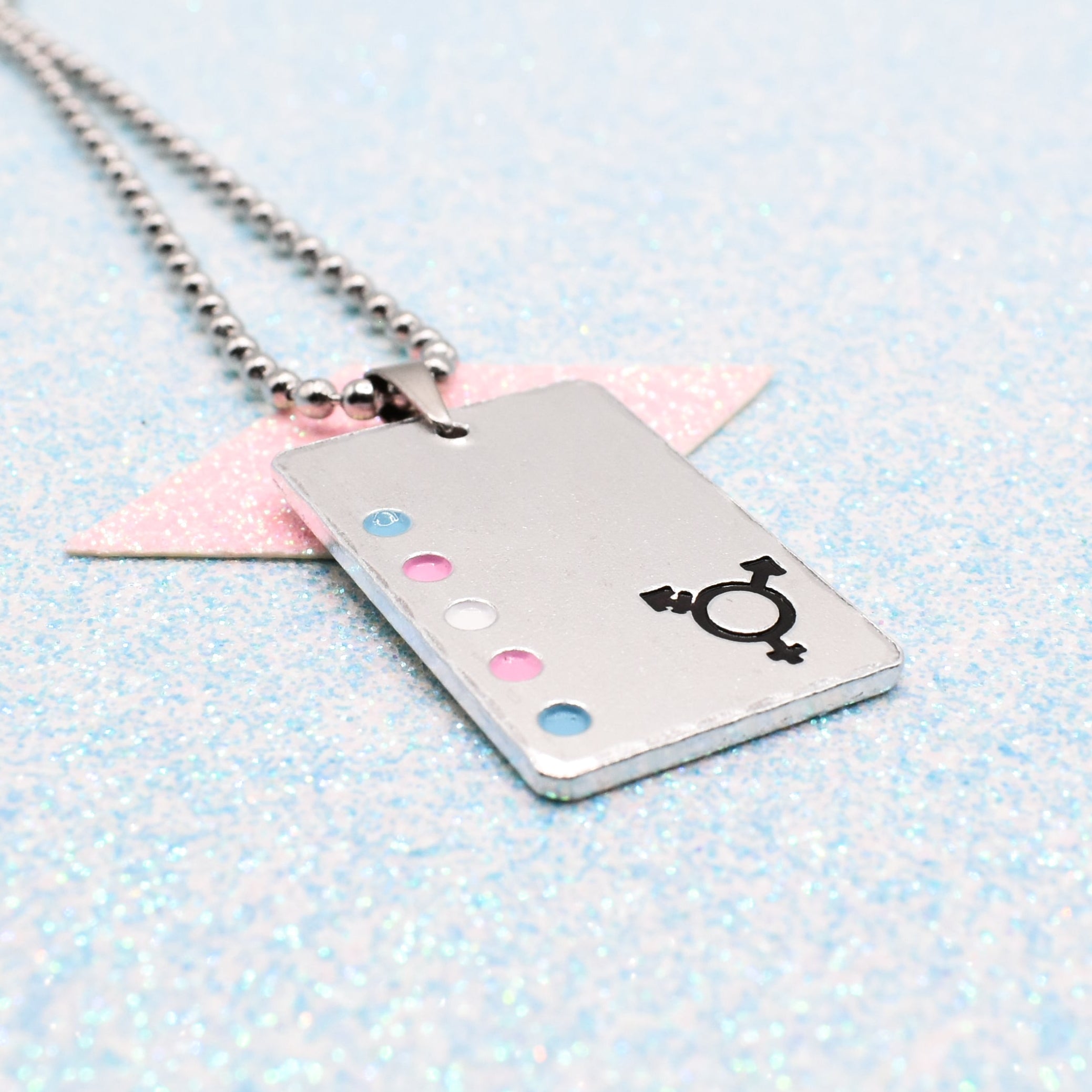 Transgender Necklace with a rectangular tag featuring a transgender symbol and accents on a light blue background